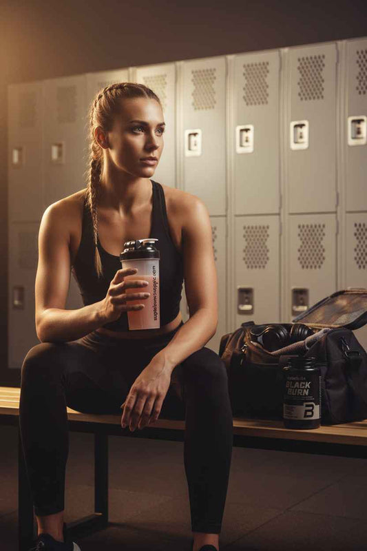 Frau mit Shaker und Black Burn Supplement im Fitnessstudio, Nahrungsergänzung für Sportler