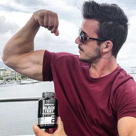 Muskulöser Mann mit Sonnenbrille zeigt Bizeps und hält Sportnahrung-Flasche