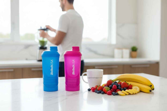 BiotechUSA Shaker in Blau und Pink mit Früchten und Smoothie im Hintergrund für Sportler und Fitness