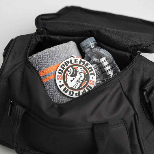 Schwarze Sporttasche mit grauem Handtuch und einer Wasserflasche im Inneren.