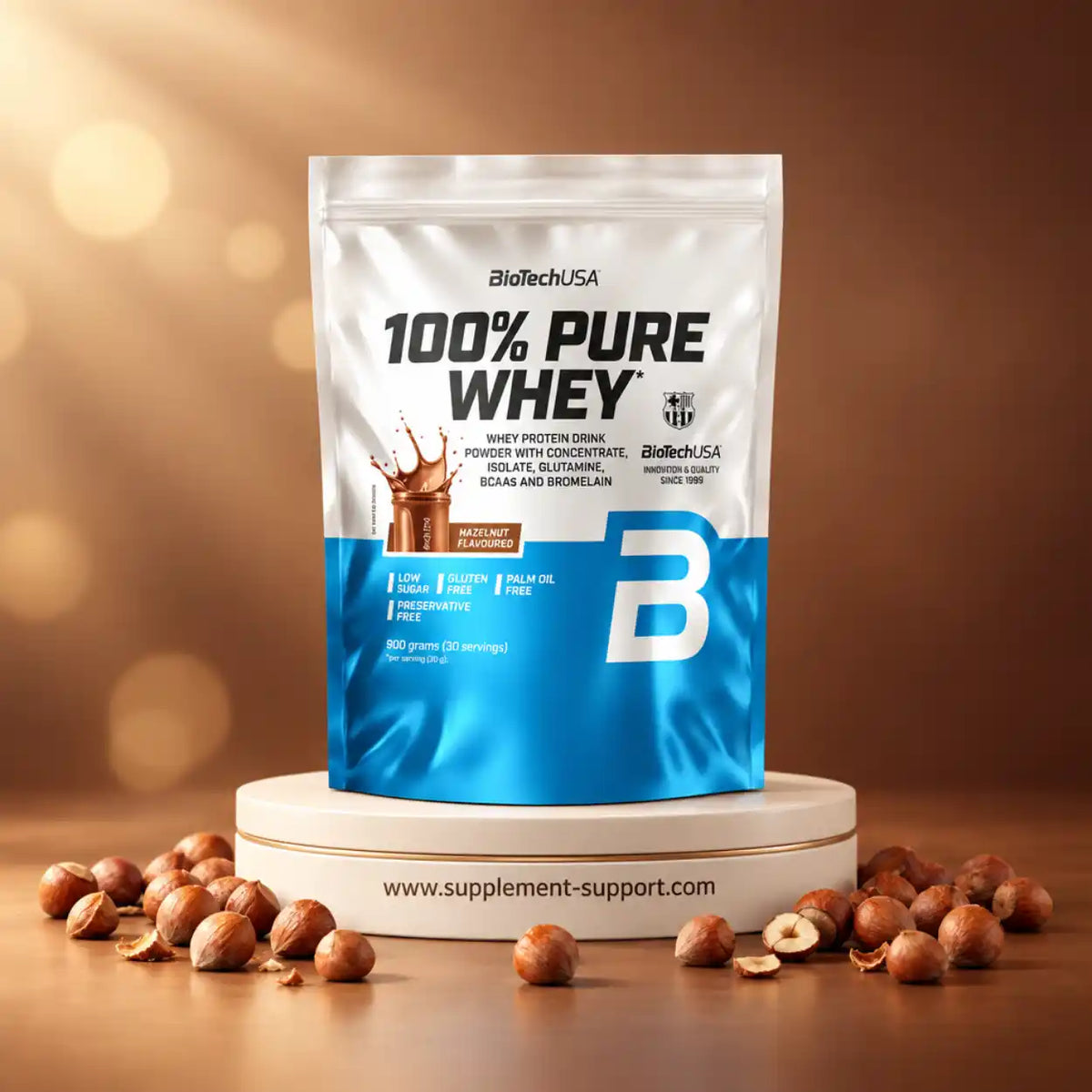 BioTech USA 100% Pure Whey Protein Pulver Haselnuss 900g auf weißem Podest mit Haselnüssen