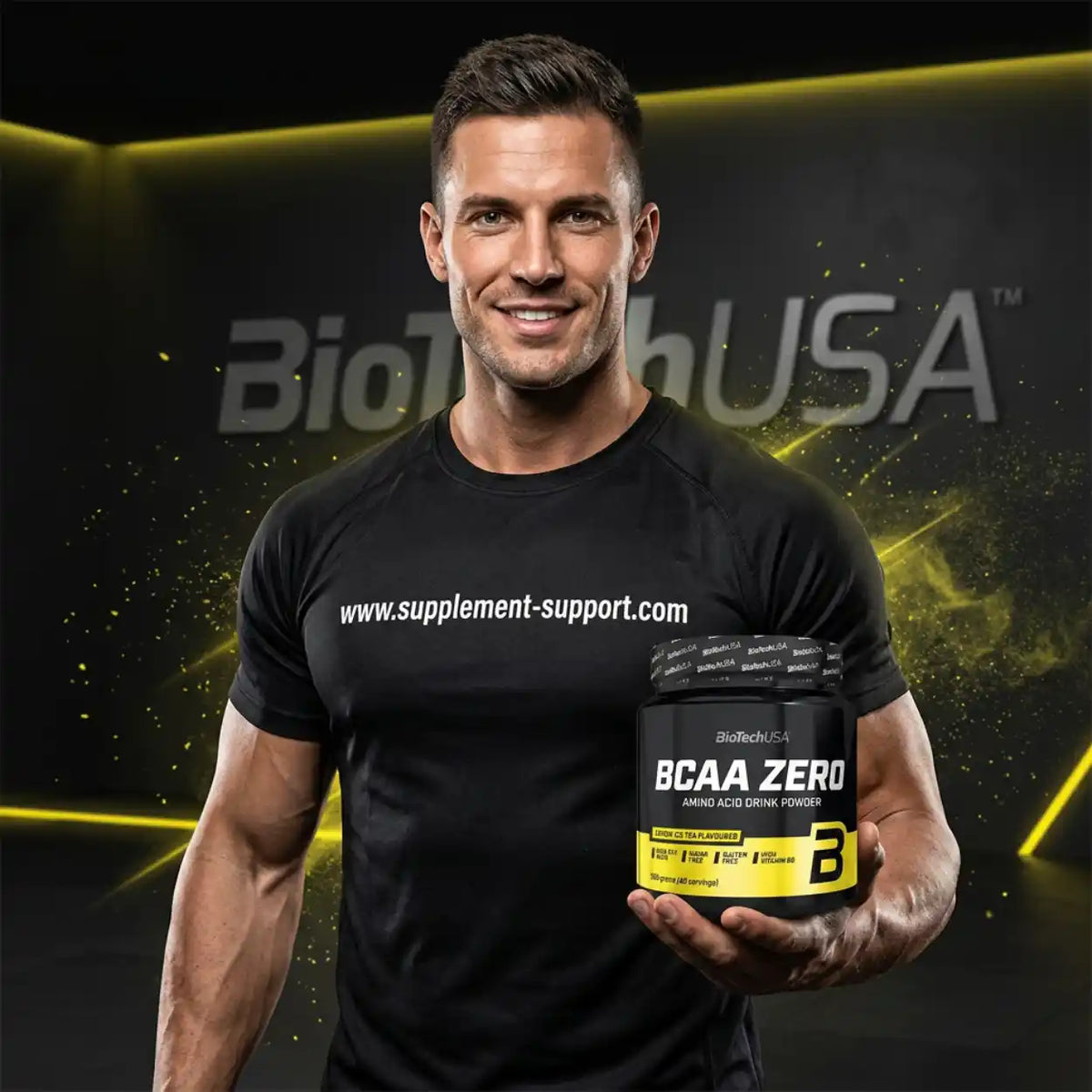 Muskulöser Mann hält ein BioTech USA BCAA ZERO Aminosäure Pulver vor dunklem Hintergrund.