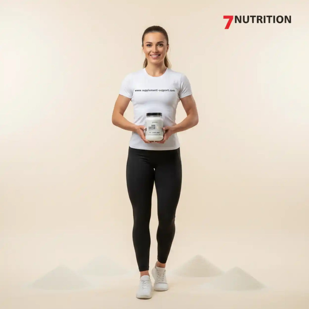 Sportliche Frau in Fitnesskleidung präsentiert ein Nahrungsergänzungsmittel von 7Nutrition.