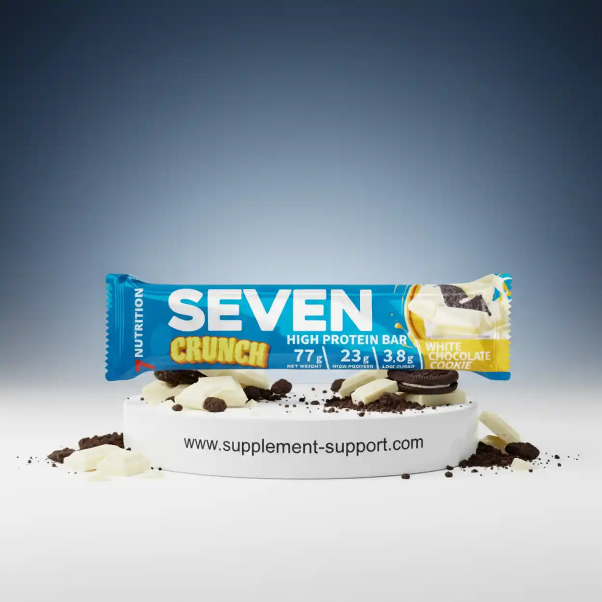 Seven Crunch High Protein Bar White Chocolate Cookie auf weißem Podest mit Keksstücken.