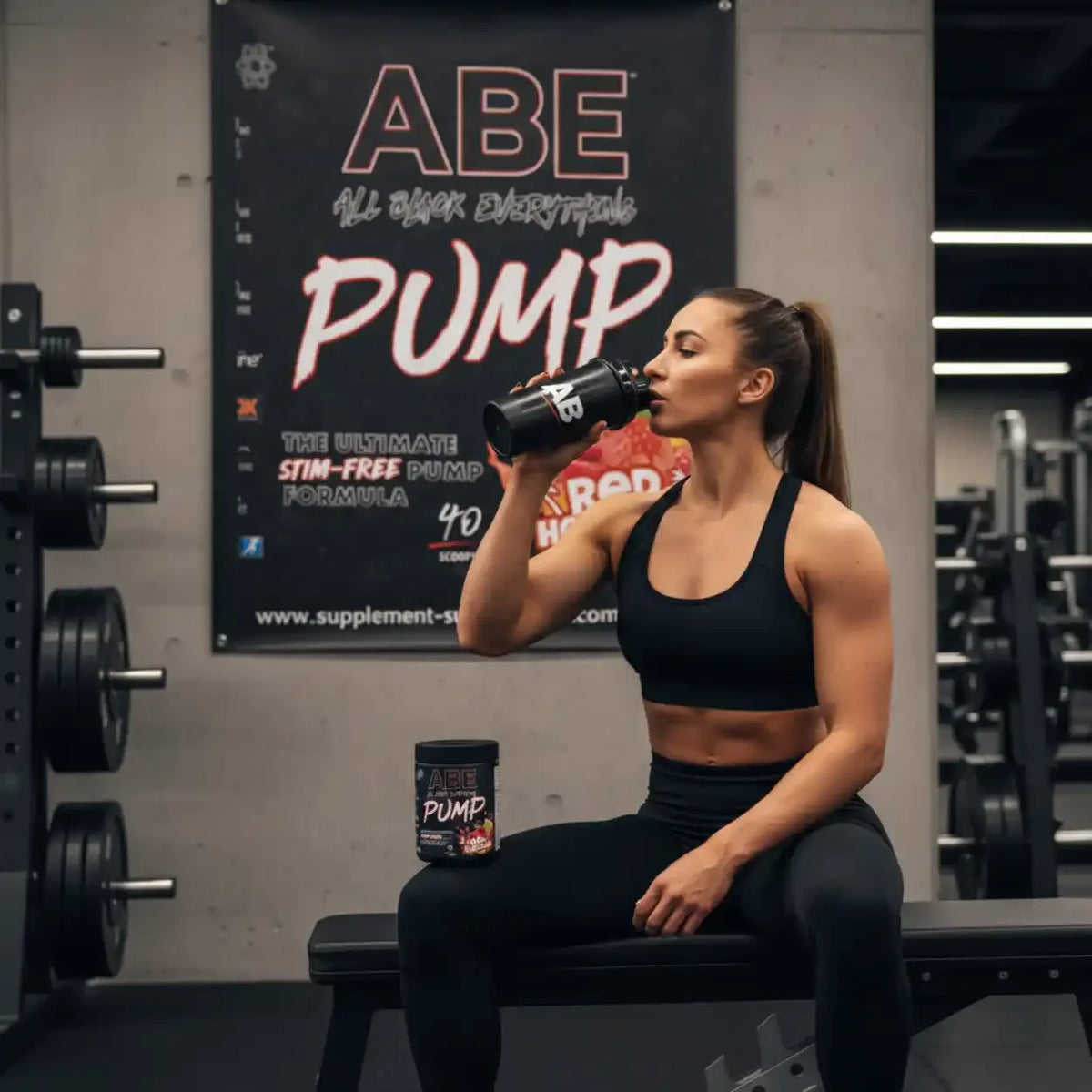 Frau im Fitnessstudio trinkt ABE Pump Booster von Applied Nutrition aus einem Shaker.