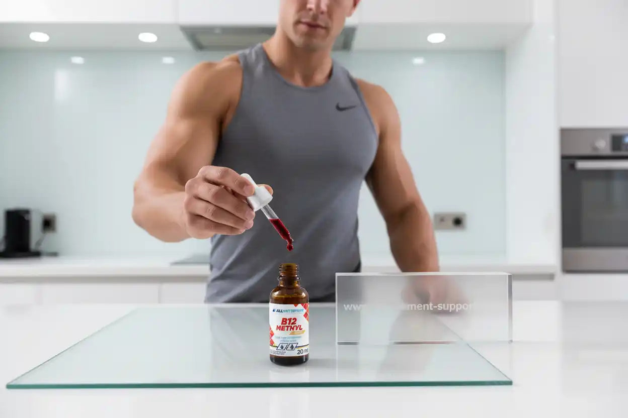 Muskulöser Mann gibt B12 Methyl Tropfen aus Flasche in moderne Küche, Sportnahrung & Nahrungsergänzung