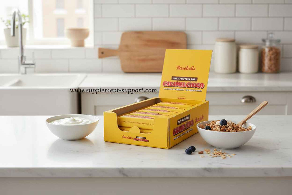 Barebells Soft Protein Bar Caramel Choco in gelber Verpackung mit Joghurt und Müsli auf Küchenarbeitsplatte
