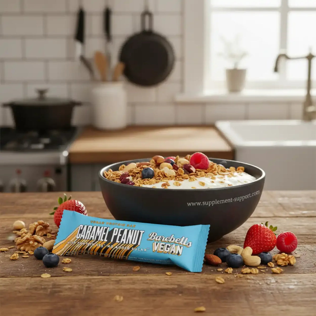 Barebells Vegan Protein Bar Caramel Peanut neben einer Bowl mit Joghurt, Beeren und Nüssen.