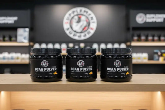 Drei schwarze Dosen BCAA Pulver auf einem Holzregal vor Supplement-Support Hintergrund