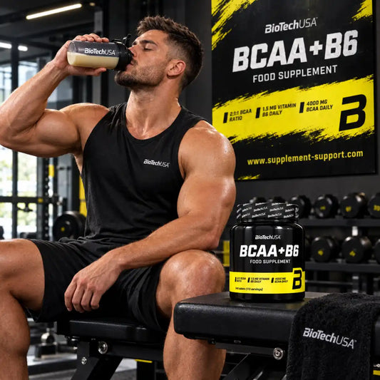 Muskulöser Mann trinkt aus einem Shaker neben BioTech USA BCAA + B6 Nahrungsergänzungsmitteln.