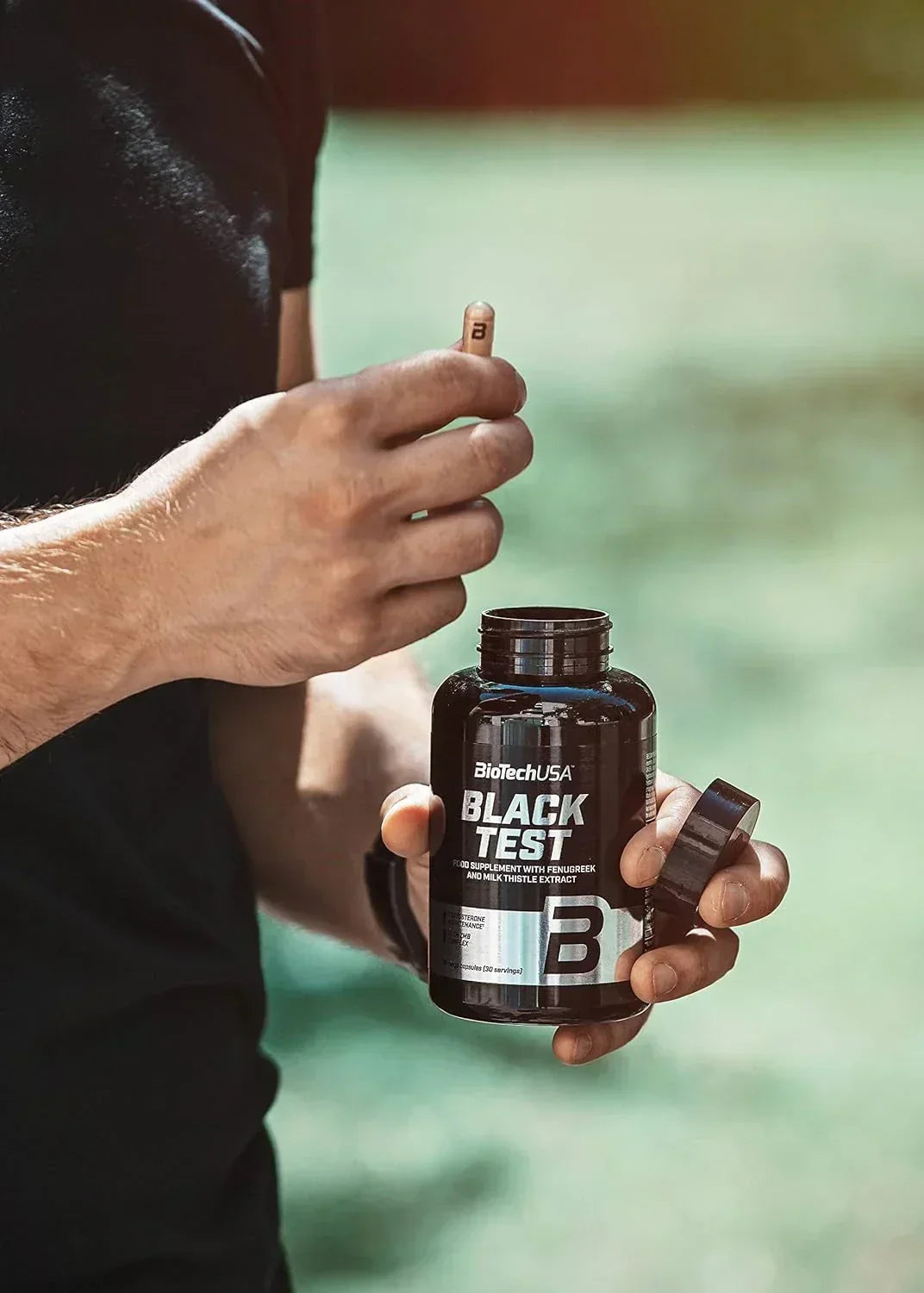 Mann hält BioTechUSA Black Test Nahrungsergänzung mit Fenugreek und Mariendistel-Extrakt