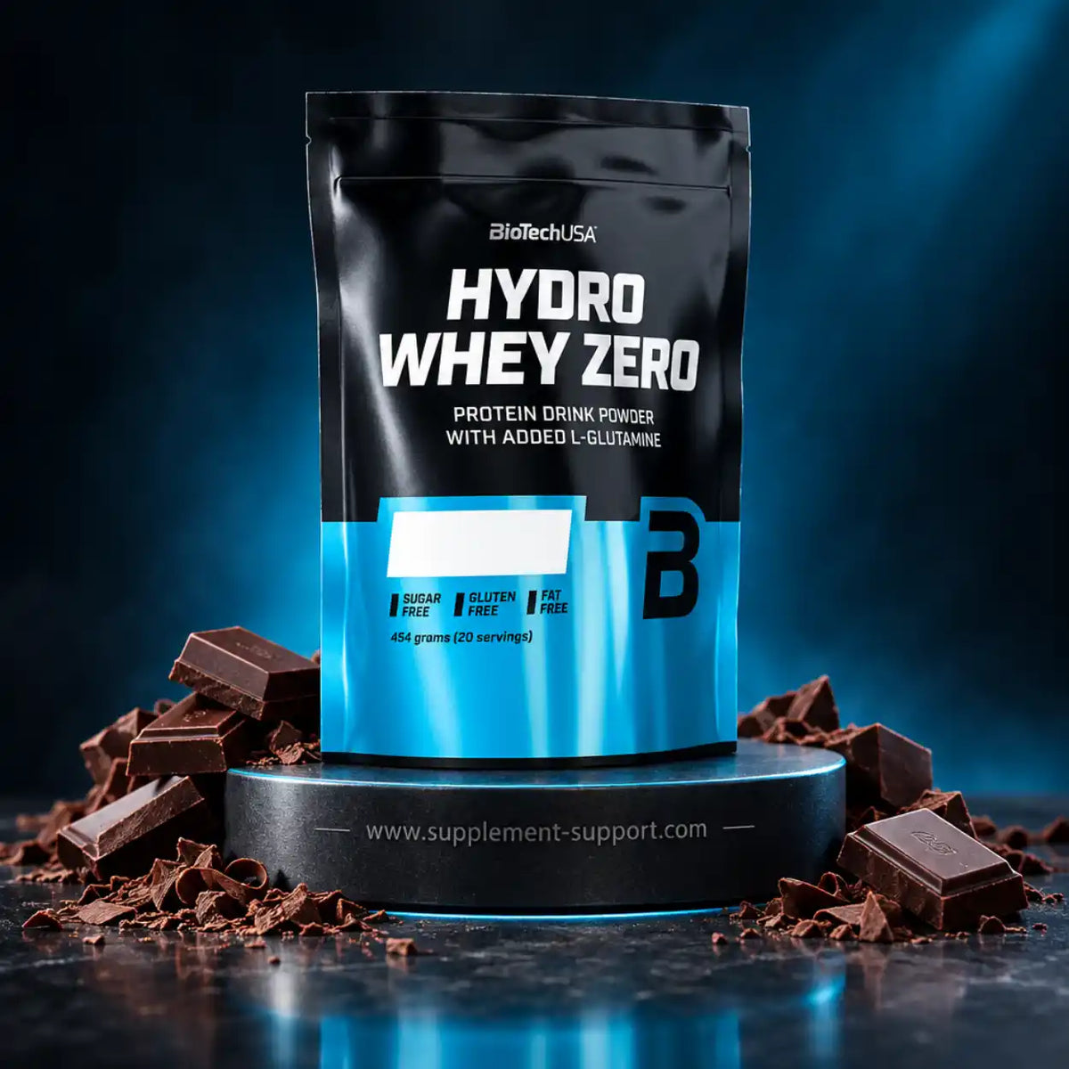 BioTech USA Hydro Whey Zero Proteinpulver Beutel auf Podest mit Schokoladenstücken