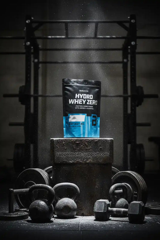 Hydro Whey Zero Proteinpulver in Fitness-Studio mit Hanteln und Kettlebells, ideal für Sportler und Fitness