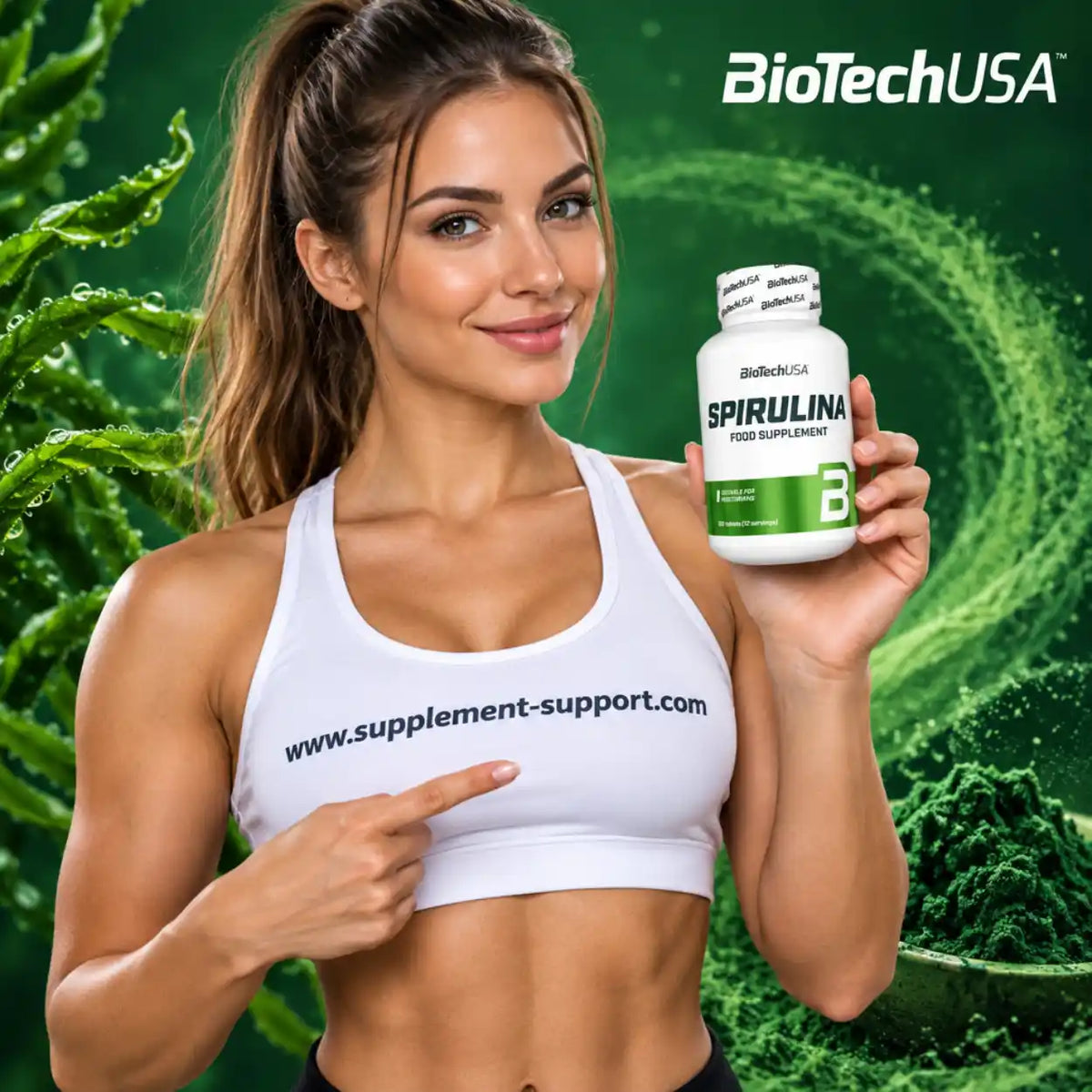 Sportliche Frau hält eine Dose BioTech USA Spirulina Nahrungsergänzung vor grünem Hintergrund.