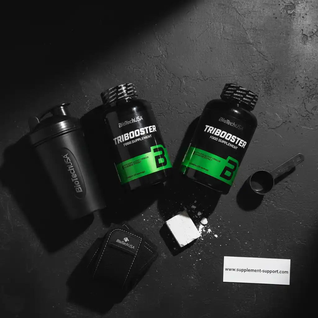 Zwei Dosen BioTechUSA Tribooster Nahrungsergänzungsmittel mit Shaker und Messlöffel.