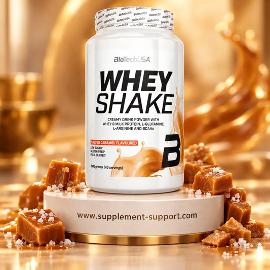 BioTech USA Whey Shake in Salted Caramel Geschmack mit Karamellwürfeln auf weißem Podest.