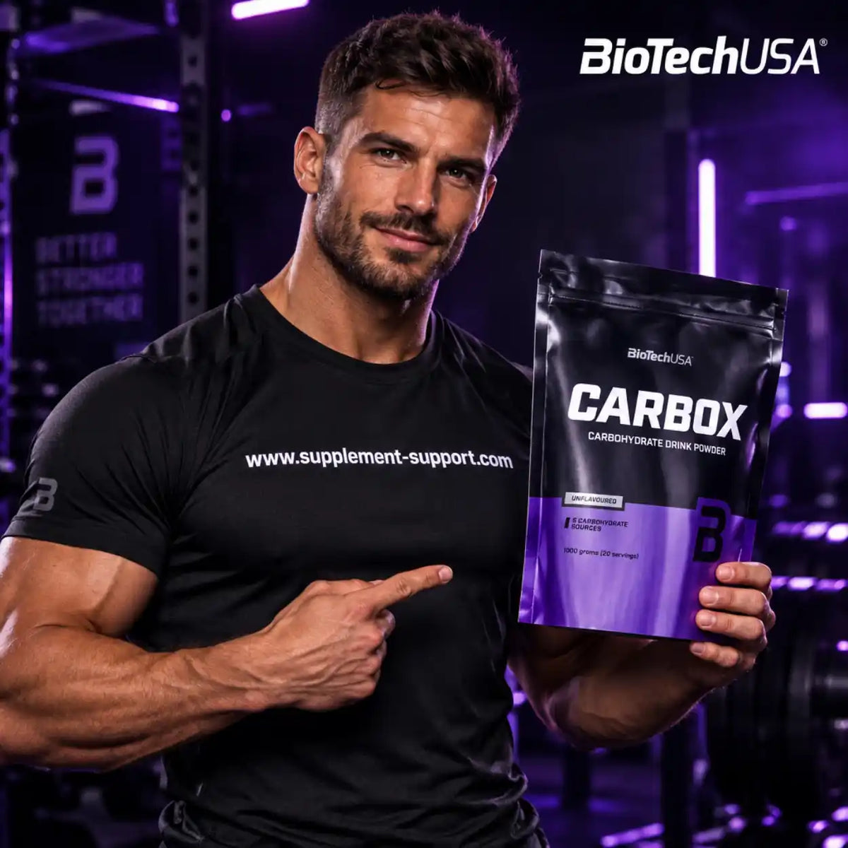Muskulöser Mann hält eine Packung BioTech USA CARBOX Kohlenhydrat-Getränkepulver im Fitnessstudio.