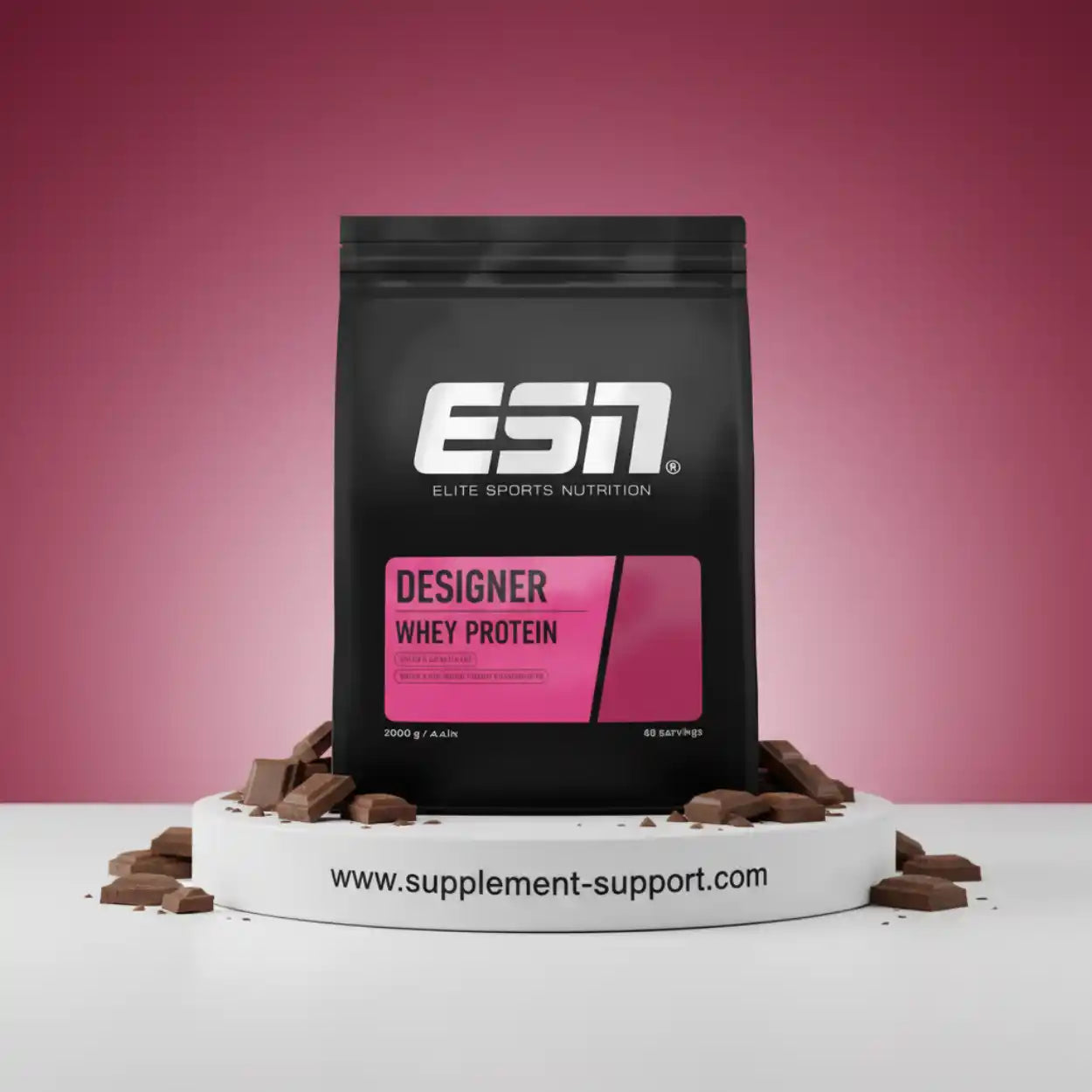 ESN Designer Whey Protein Schoko Pulver im schwarzen Beutel vor rosa Hintergrund, umgeben von Schokostücken.