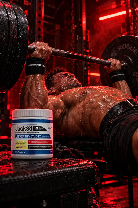 Muskulöser Mann beim Bankdrücken mit USP Labs Jack3d Advanced Pre-Workout Booster im Vordergrund.