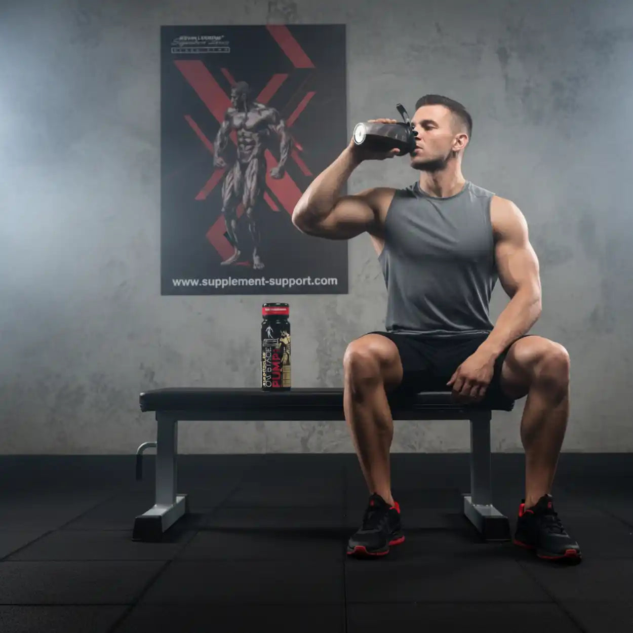 Sportlicher Mann trinkt Shake im Fitnessstudio, Muskelaufbau Supplement auf Bank