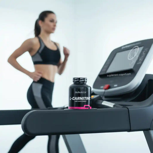 L-Carnitin-Flasche auf Laufband im Fitnessstudio, Frau joggt im Hintergrund – Sportnahrung & Nahrungsergänzung
