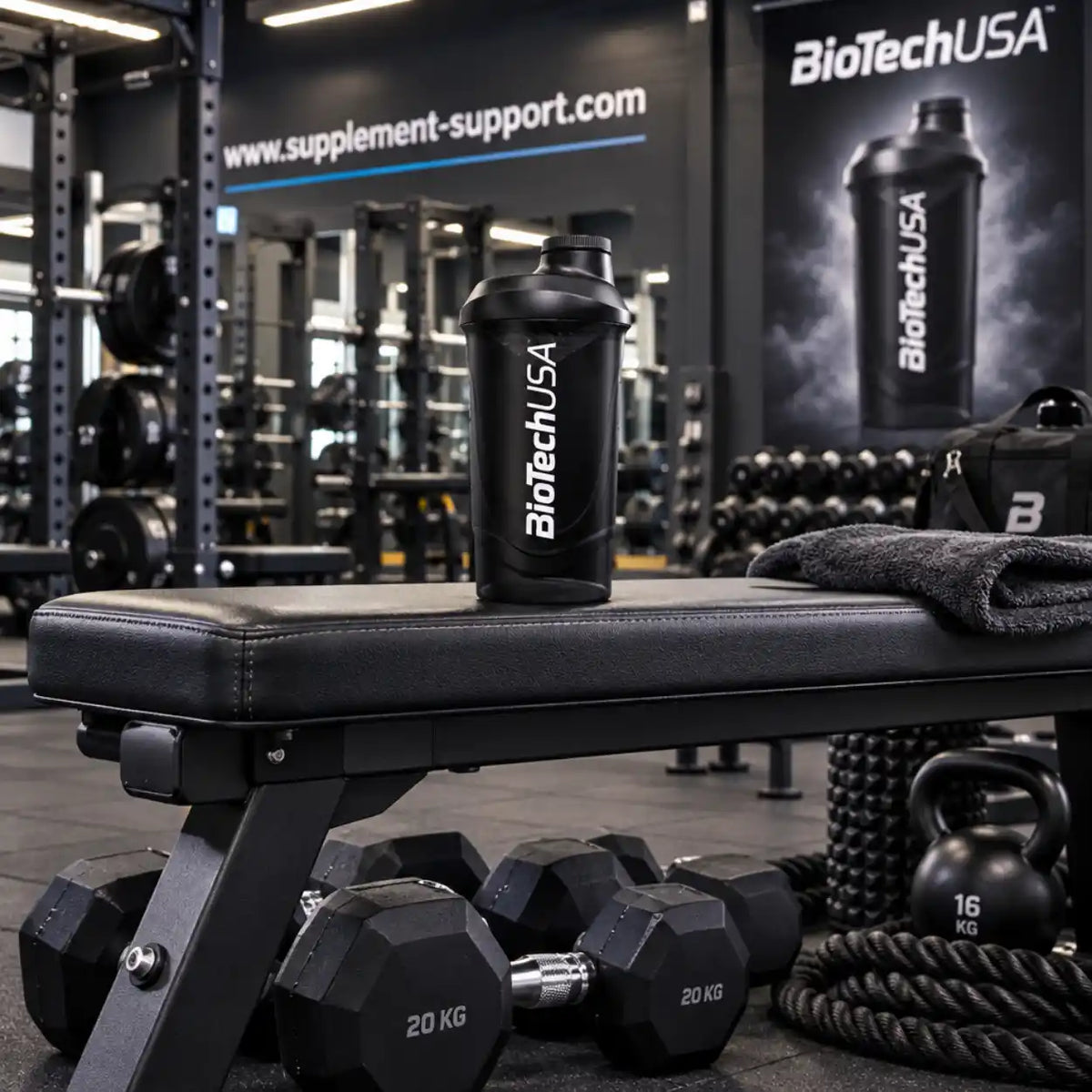 Schwarzer BioTech USA Protein Shaker auf einer Hantelbank im Fitnessstudio