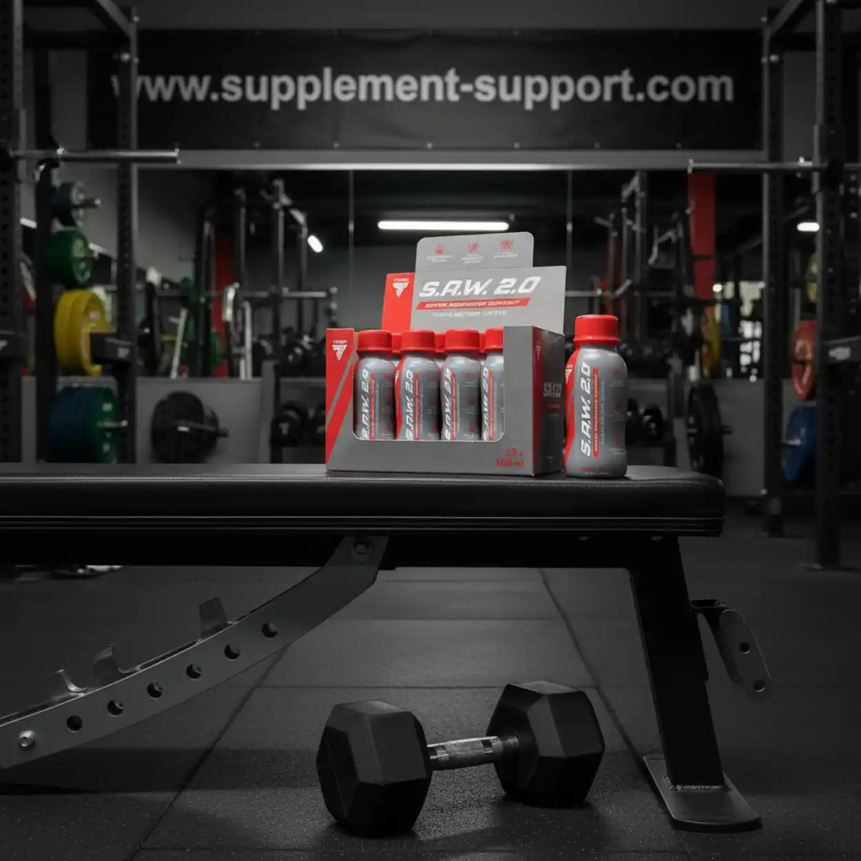 S.A.W. 2.0 Booster Shots im Fitnessstudio auf Hantelbank, Hantel im Vordergrund