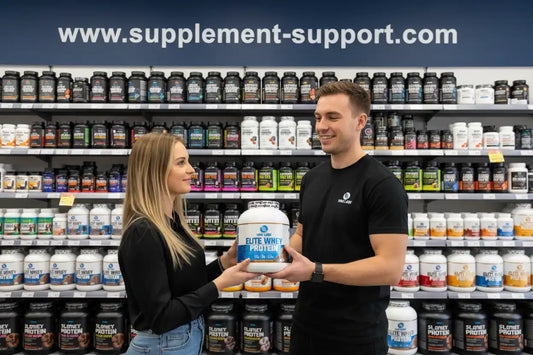 Mann und Frau halten Elite Whey Protein in Supplement-Store mit Regalen voller Sportnahrung