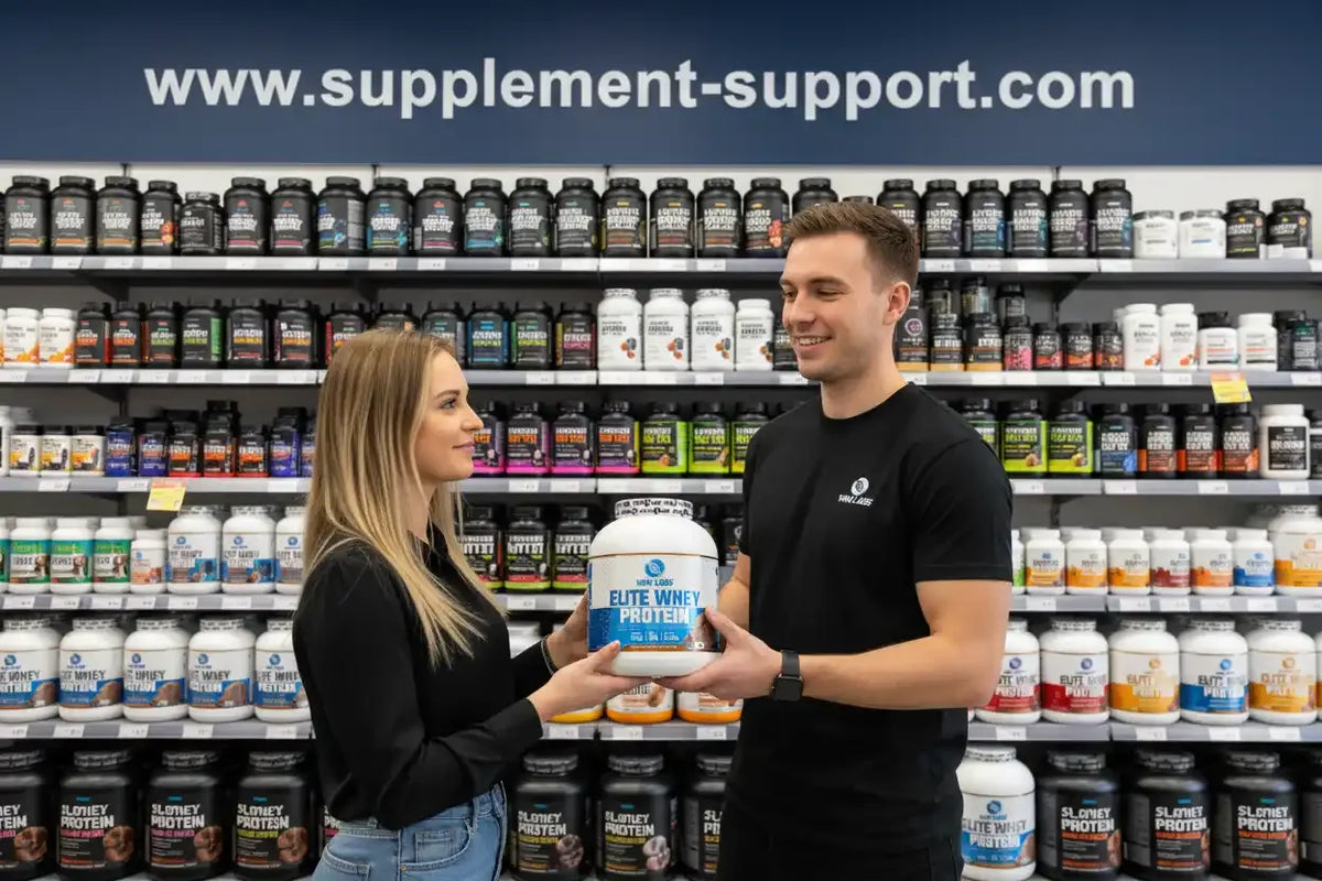 Mann und Frau halten Elite Whey Protein in Supplement-Store mit Regalen voller Sportnahrung
